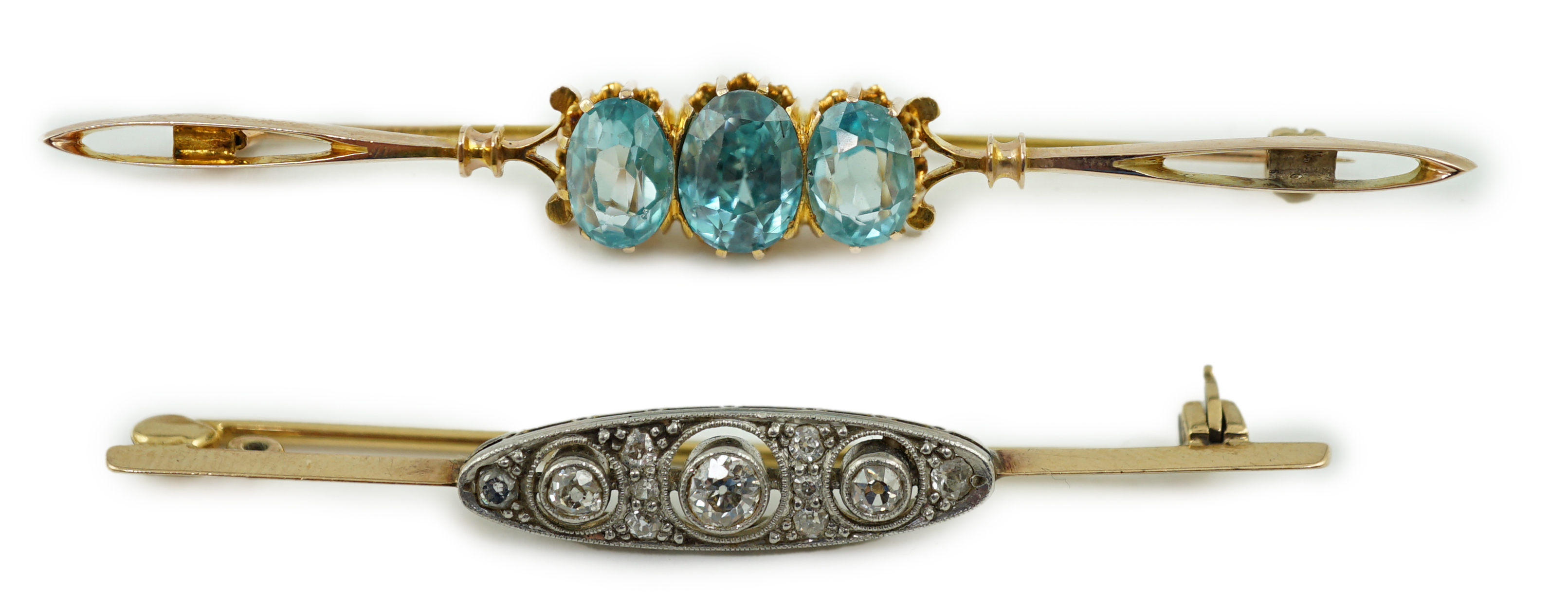 A 1920's yellow metal and millegrain diamond cluster set bar brooch, 56mm, together with a yellow metal and three stone blue zircon set bar brooch